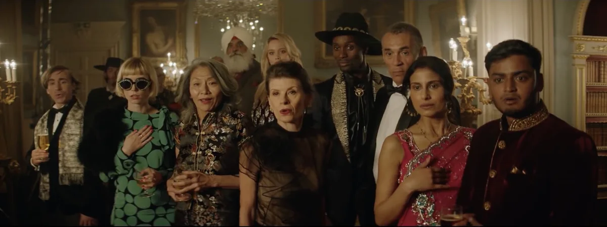 Frame from the Brew City Beermunch advert: a formally dressed crowd in a gilded ballroom