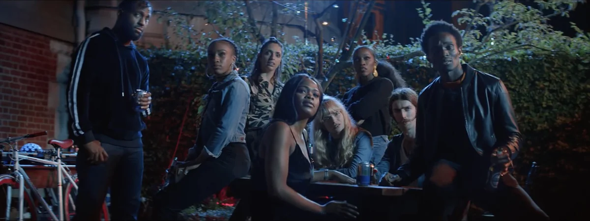 Frame from the Brew City Beermunch advert: a group around a picnic table in a yard at night