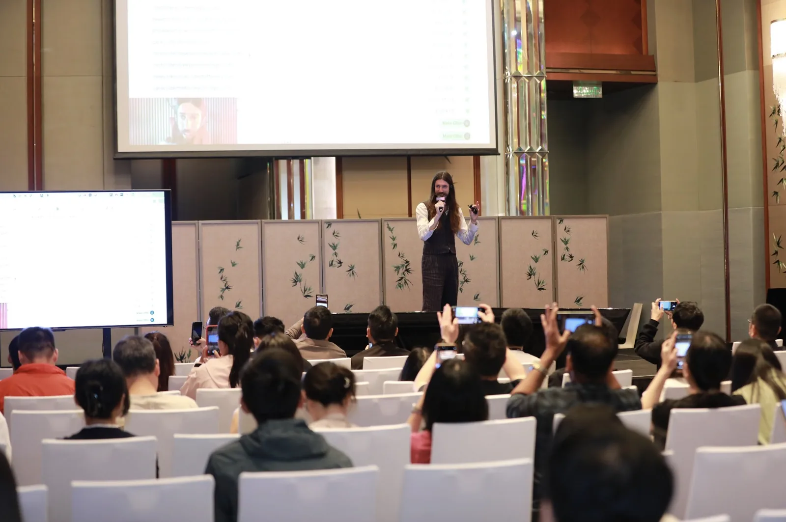 Stewart Vickers on stage at Shenzhen SEO Conference 2025 while the audience searches on their phones